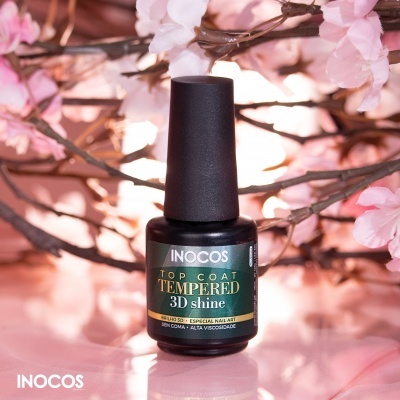 Frasco preto de verniz INOCOS Top Coat Tempered 3D shine com flores cor de rosa ao fundo