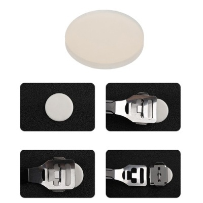 Disco branco redondo e peças metálicas prateadas num fundo preto