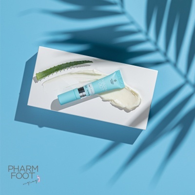 tubo de creme cosmético azul claro sobre fundo branco e azul com sombra de planta e folha verde