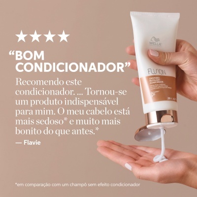 Mão segurando tubo branco de condicionador Wella Fusion com creme a sair para a mão oposta