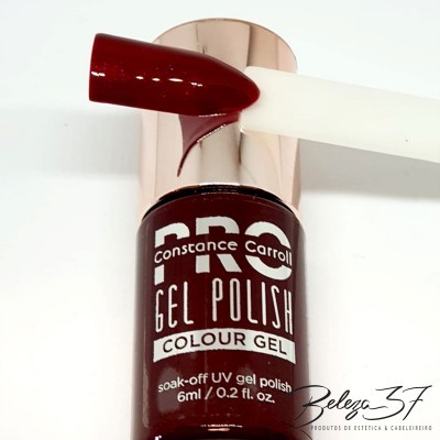 Frasco de verniz gel Constance Carroll cor bordô com amostra da cor numa unha de plástico