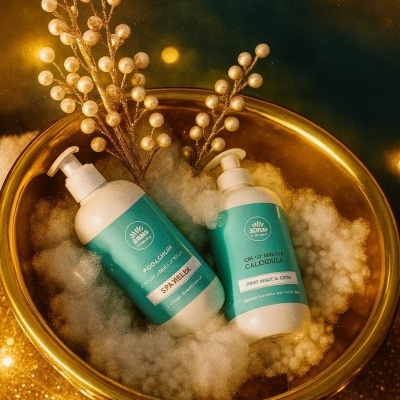 Duas embalagens de produtos com tampas de bomba em bacia dourada com algodão e decoração dourada.