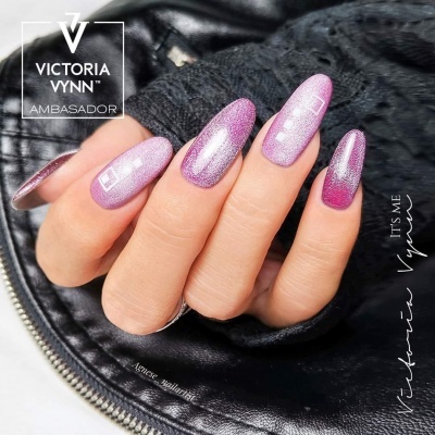 Unhas longas pintadas de rosa e lilás com glitter sobre couro preto