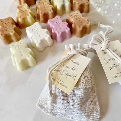 Sabonetes ursinhos coloridos e sacos de tecido com etiquetas penduradas