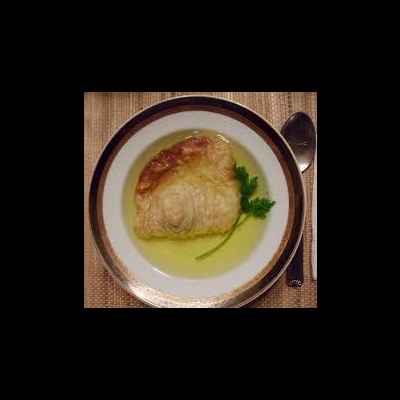 Prato com carne grelhada, molho e salsa, colher ao lado