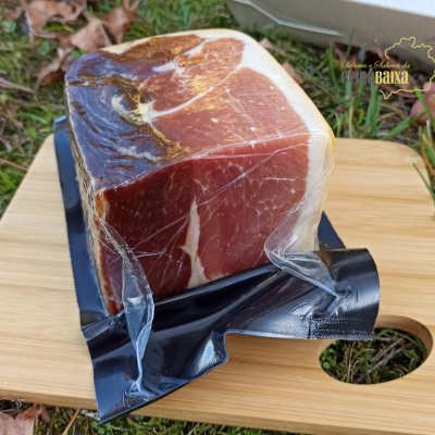 Pedaço de presunto curado embalado sobre tábua de madeira ao ar livre