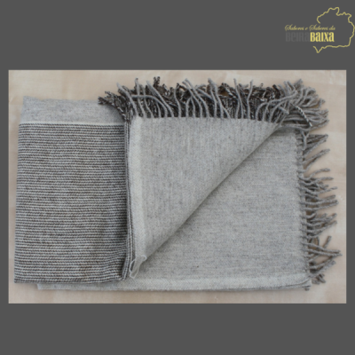 Manta cinzenta com franjas e padrão listrado e liso