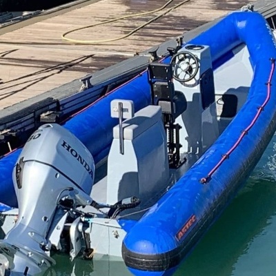 Barco insuflável azul com motor Honda cinza no cais