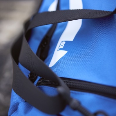 Mala desportiva azul com alças pretas e texto branco '100%'