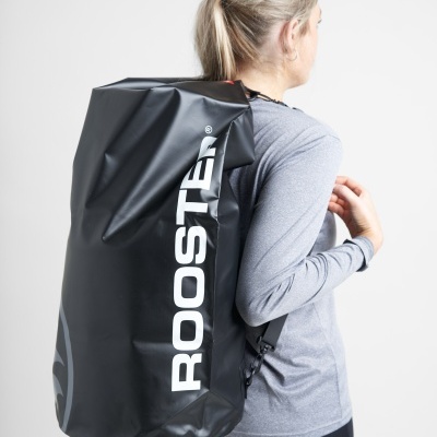 Mulher com mochila impermeável preta ROOSTER vestindo camiseta cinza e calças pretas