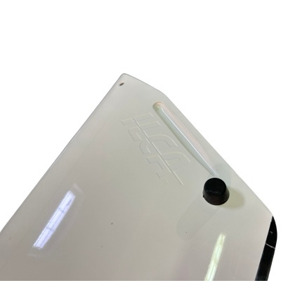 Painel branco cilíndrico com inscrição em relevo e botão preto