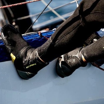 Botas de mergulho pretas com texto 'SPLIT TOE' usadas no barco