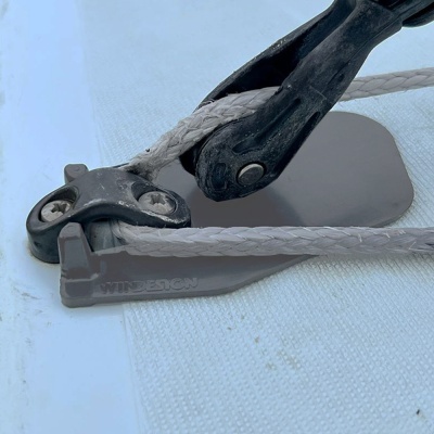 Equipamento náutico com cordas e peças plásticas e metálicas sobre superfície branca