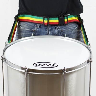 Tambor prateado com pele branca e logotipo OZZI com cinto colorido usado por pessoa