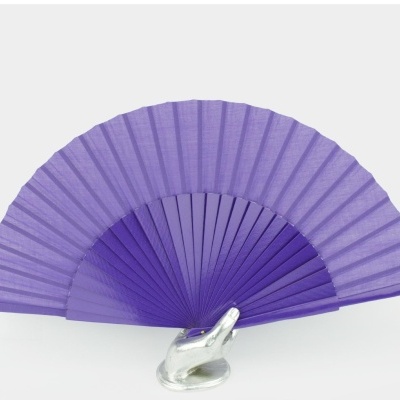 Leque lilás e roxo apoiado em base metálica em forma de mão