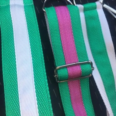 Três correias de tecido com riscas verdes, brancas e cor-de-rosa com argolas metálicas
