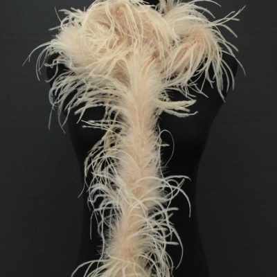 Cachecol de plumas bege claro sobre manequim preto