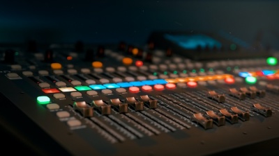 Mesa de mistura de áudio com botões iluminados e faders