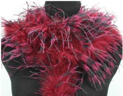 Lenço decorativo feito com penas vermelhas, rosas e pretas num manequim preto