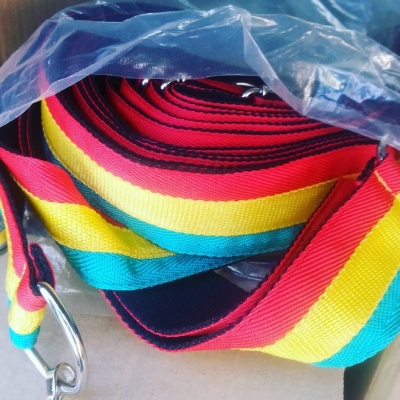 Correia colorida em tecido com fivelas metálicas dentro de saco plástico