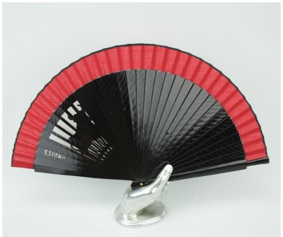 Leque tradicional vermelho e preto com texto ESPAÑA, apoiado numa escultura de mão prateada.
