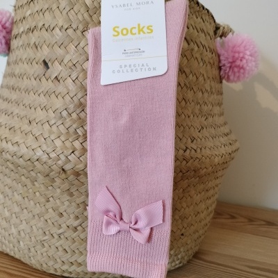 Meias cor-de-rosa com laço penduradas numa cesta de palha com pompons cor-de-rosa