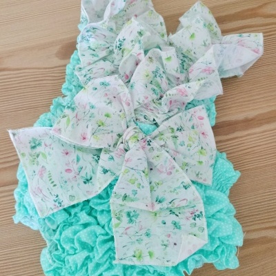 Roupa infantil azul claro com laço florido branco