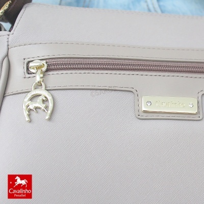 Bolsa bege clara com fecho e pendente dourado, placa metálica Cavalinho