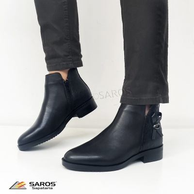 Botas pretas femininas em pele com laço e fivela, usadas com calças pretas