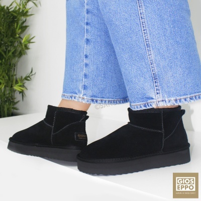 Botas pretas em camurça com sola preta e etiqueta GIOSEPPO, usadas com jeans azuis