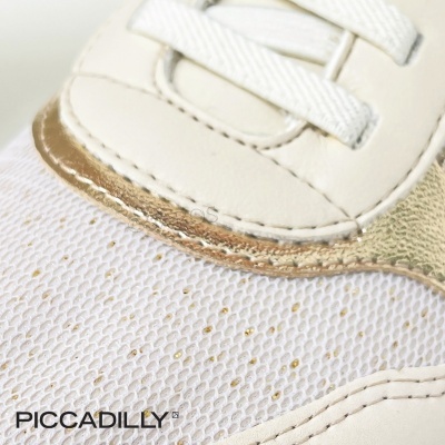 Detalhe de ténis branco com dourado e texturas variadas da marca PICCADILLY