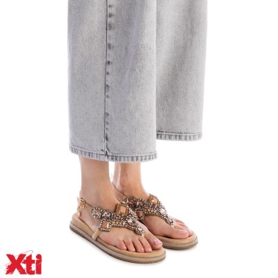 Sandálias rasas bege com pedras brilhantes usadas com calças de ganga cinza claro