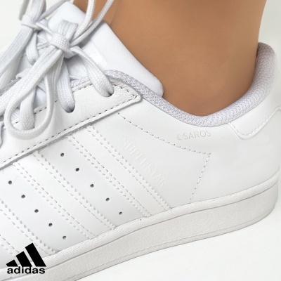 Ténis brancos Adidas SuperStar com atacadores na cor branca e detalhes cinzentos no interior