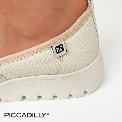 Sapatilha creme com sola branca grossa e etiqueta preta da marca PICCADILLY