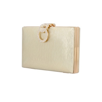 Carteira clutch dourada com fecho decorado em fundo branco
