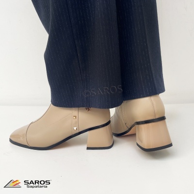 Botas femininas bege com salto quadrado em couro verniz e detalhe de studs dourados