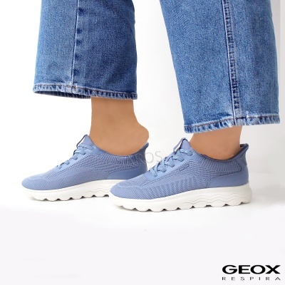 Ténis de corrida azuis claros com sola branca e calças de ganga azuis