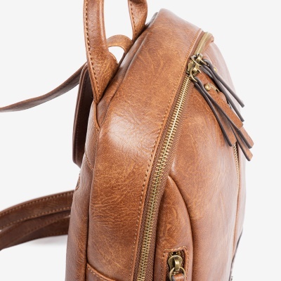 Mochila pequena castanha em couro com zíper dourado num fundo branco