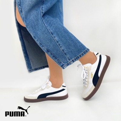 Ténis Puma brancos com detalhes azul escuro e sola castanha