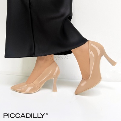 Sapatos de salto alto nude em verniz com bico fino, usados com saia preta comprida.