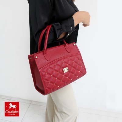Mala vermelha de pele com padrão matelassé e detalhes metálicos