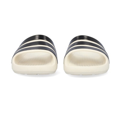 Chinelos creme e pretos com riscas horizontais pretas, fundo branco