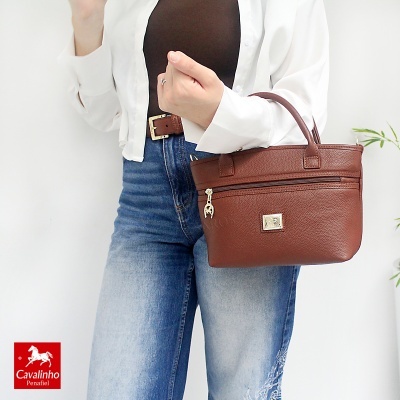 Mala de mão castanha Cavalinho Penafiel em pele usada com roupa casual
