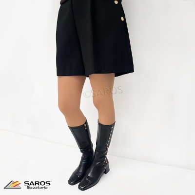 Bota preta feminina em couro sintético com tachas douradas, salto médio e fecho lateral