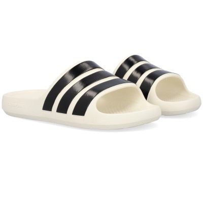 Chinelos brancos com riscas pretas em fundo branco