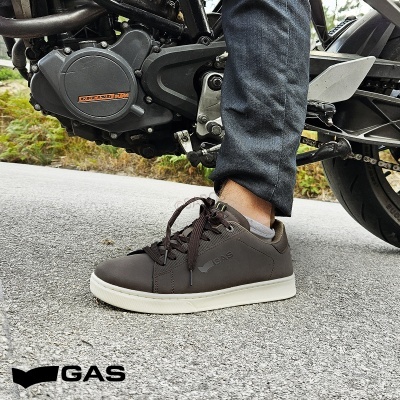 Ténis pretos GAS com sola branca usados junto a uma moto.
