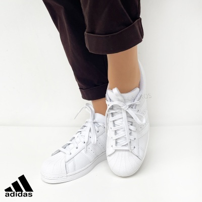 Ténis Adidas brancos com caraterísticas riscas em pele sintética