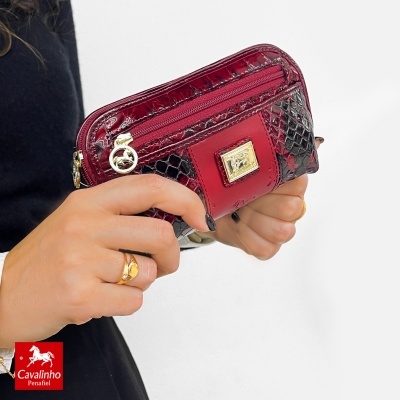 Carteira em pele vermelha e preta com padrão de pele de cobra e detalhes dourados