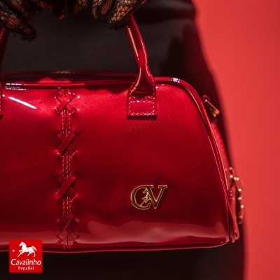 Mala de mão vermelha brilhante com detalhe X e logo dourado CV