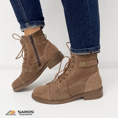 Botas castanhas em camurça com atacadores e fecho lateral, usadas com calças azul escuro